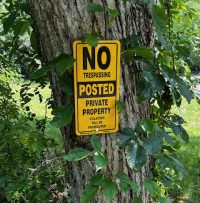veritcal posted sign on tree