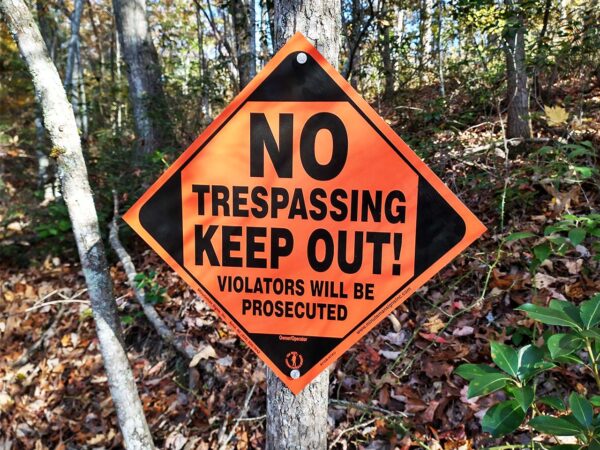 Orange posted sign on tree